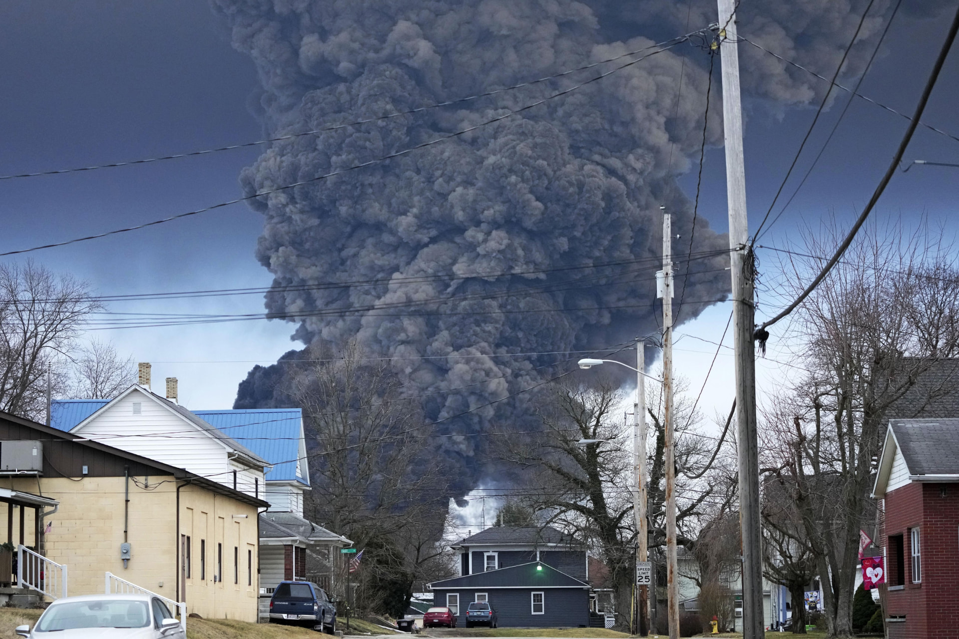 Plume of dark smoke rising over a residential neighborhood